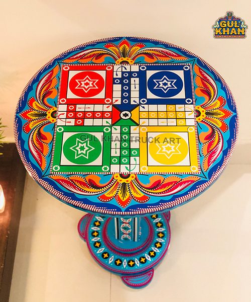 Colorful round coffee table with traditional truck art paint and ludo board design on top