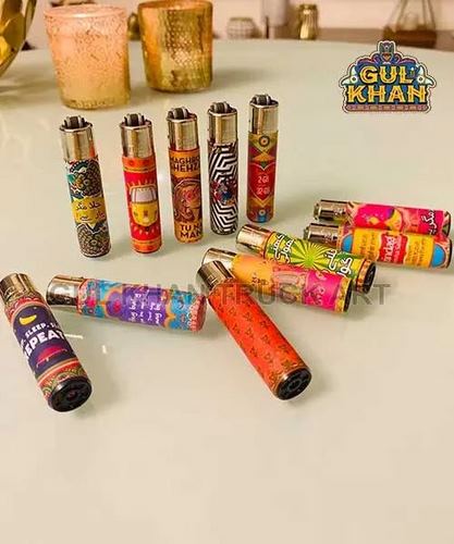 Colorful Gul Khan branded lighters with vibrant, patterned designs arranged on a white table