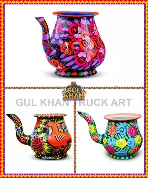 Three colorful hand-painted metal water jugs with floral and bird designs, traditional truck art style