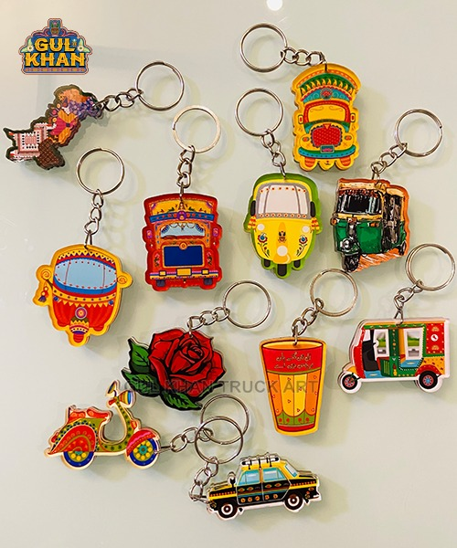Colorful acrylic keychains featuring auto rickshaws, scooters, taxi, rose, and chai glass designs