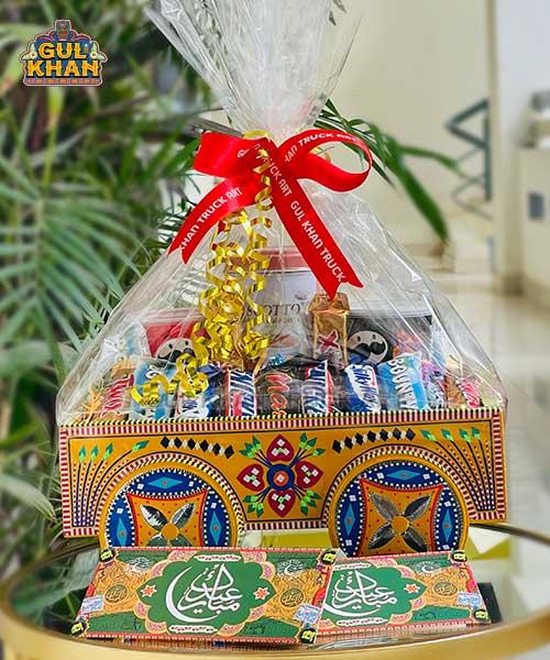 Colorful gift basket wrapped in clear plastic with red bow, filled with assorted chocolates and treats